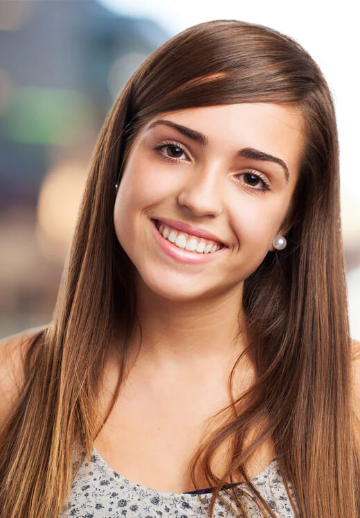 Young woman smiling at camera, professional headshot for dental practice website.